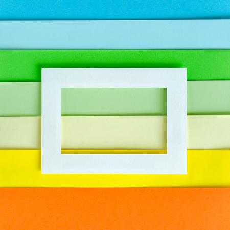 Sheets of colored paper and a white empty frame. Abstract backgroundの写真素材