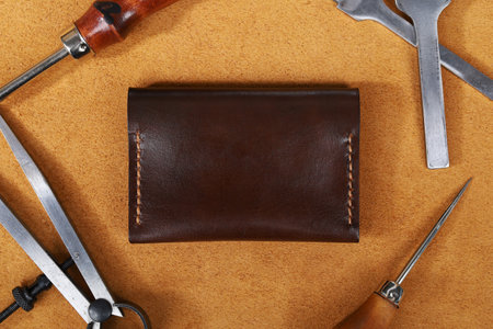 Dark Brown Leather Wallet Isolated on Leather with Leather Crafting Tools