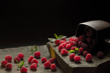 Mug filled with red, ripe raspberries.