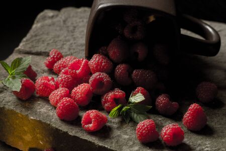 Mug filled with red, ripe raspberries.の写真素材