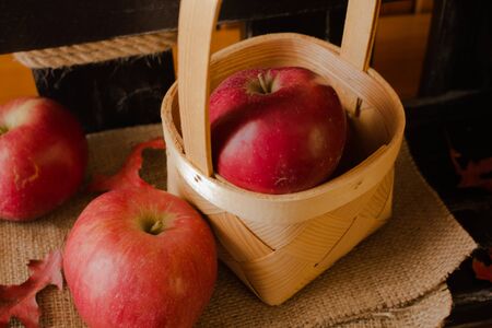 Ripe red apples against the background of a decorative rustic little fence.の写真素材