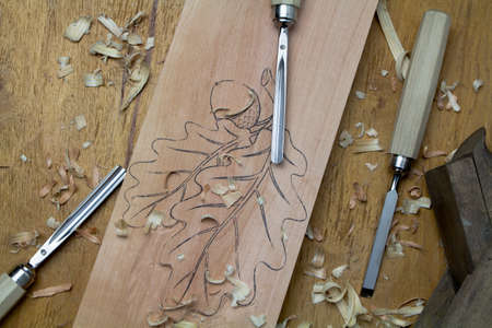 Carving chisels with carved board and shavings.