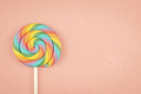 Pastel colored lollipop on light pink background with copy space.の写真素材