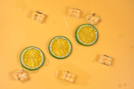Lime slices on orange with Water from melting ice cubes.の写真素材