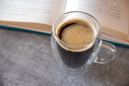 Top view for cup of coffee on grey background and bookの写真素材