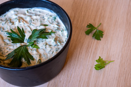 parsley with tahini mixed and served in black plate with wooden backgroundの写真素材