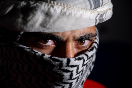 portrait of pearson wearing white keffiyeh on dark background with anger expression on his eyes due to violence and against occupationの写真素材