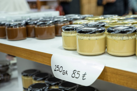 jars of cream on store shelf with price tag under the jar on black backgroundの写真素材