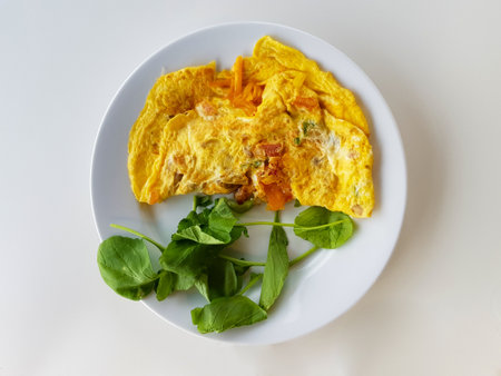 Scrambled eggs with greens on white plate and white table from top viewの写真素材
