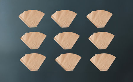 Coffee filter used for american coffee machine  on green background with mockup spaceの写真素材