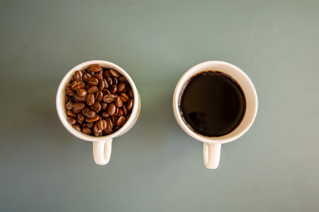 Coffee cups on green background  full of coffee beans and drink