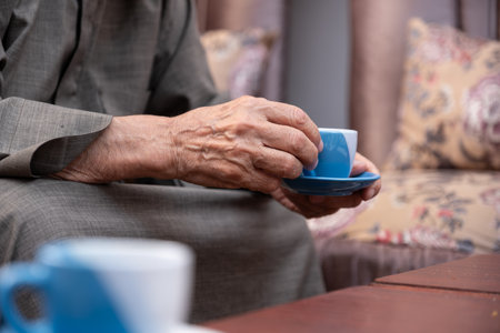 Old man drinking coffee with smile on his faceの写真素材