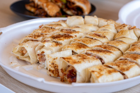 Pieces of shawarma on wooden table with dips and arranged on white plateの写真素材