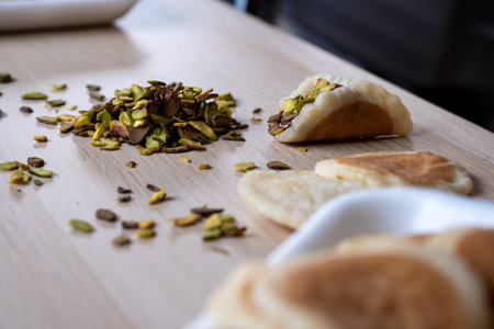 Piece of qatayef on wooden table stuffed with pistachio and chocolateの写真素材