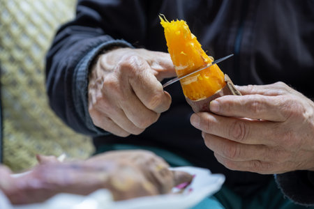 Old man eating sweet potatoの写真素材