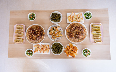 arabian dining table consist of rolls of cabbage rolls of grape , rice ,chicken, sambousek and qatayef without peopleの写真素材