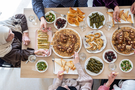 Top view for Arabian family having dinner together on wooden table with father,mother,grandfather,grandmother and sonの写真素材