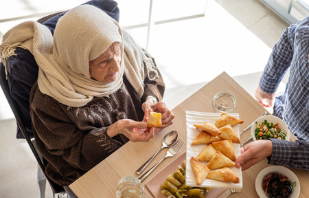 Family eating together with multi generation members in modern living roomの写真素材