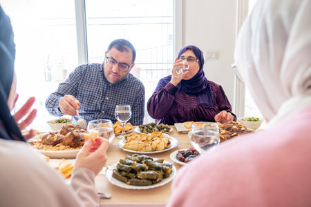 Arabian family having dinner together on wooden table with father,mother,grandfather,grandmother and sonの写真素材