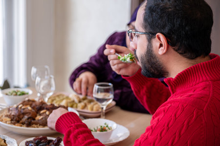 young bearded man talking to his mother on during lunchの写真素材