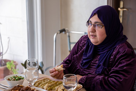 Portrait for mid age muslim woman on dining table with smile on her faceの写真素材