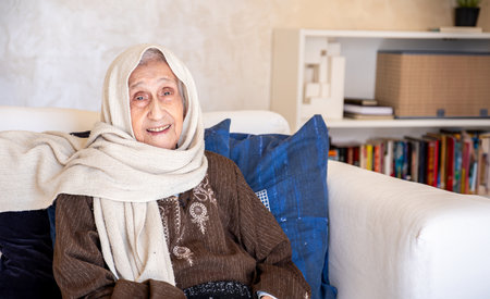 portrait for old woman in modern living and library in the background room with cheerful look on her faceの写真素材