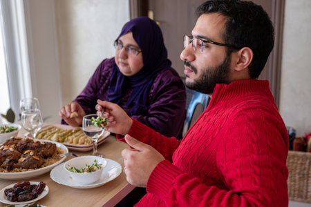 young bearded man talking to his mother on during lunchの写真素材