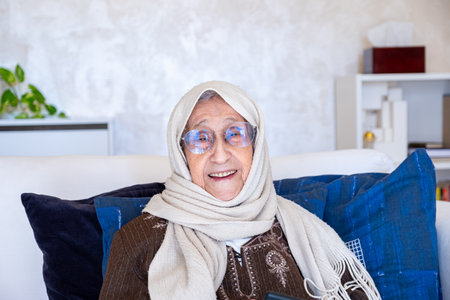 portrait for cheerful old woman wearing eyeglasses in modern living roomの写真素材