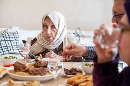 Family eating together with multi generation members in modern living roomの写真素材