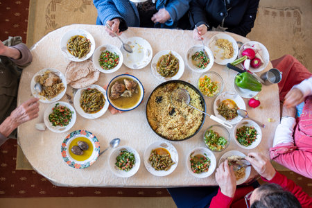 Top view of Muslim family having Iftar dinner drinking water to break feast. Eating traditional food during Ramadan feasting month at home. The Islamic Halal Eating and Drinking in modern homeの写真素材