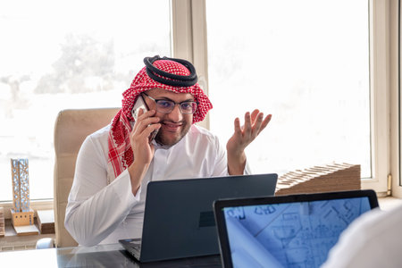 arabic male using phone during work to make sure it is flow is in the right directionの写真素材