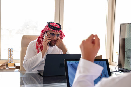 arabic male using phone during work to make sure it is flow is in the right directionの写真素材