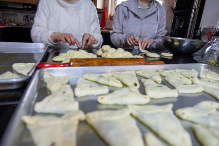 preparing arabic traditional pastries by female hands stuffing them with spinach and red chiliの写真素材