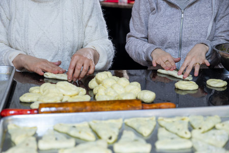 preparing arabic traditional pastries by female hands stuffing them with spinach and red chiliの写真素材