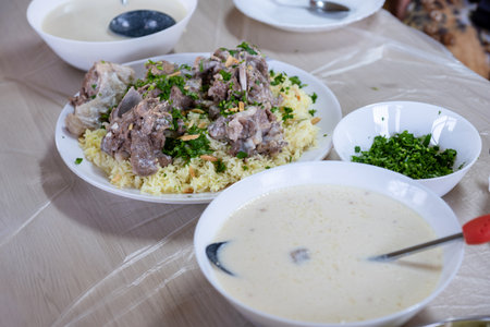 Jordanian mansaf on family table for dinner ready to be eaten looks hot and fresh with meat and...
