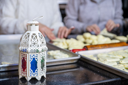 mother and daughter are working together preparing pastries for iftar in ramadan with lantern in front, ramadan patternの写真素材