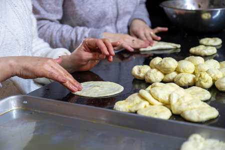 preparing arabic traditional pastries by female hands stuffing them with spinach and red chiliの写真素材