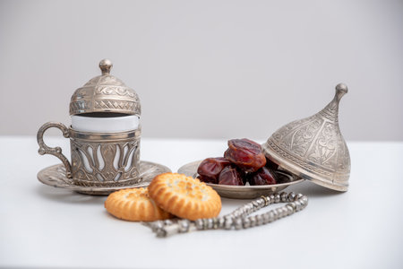 dates kahk eid sweets rosary and coffee cups on white isolated backgroundの写真素材