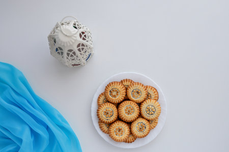 Top view of eid sweets and fanos on white table