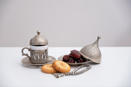 dates kahk eid sweets rosary and coffee cups on white isolated background