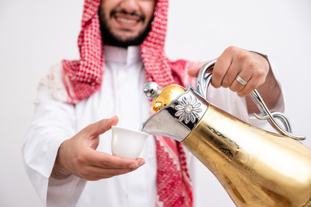 Arabian man holding arabic coffee pot wearing dishdasha and kandura on isolated white background...