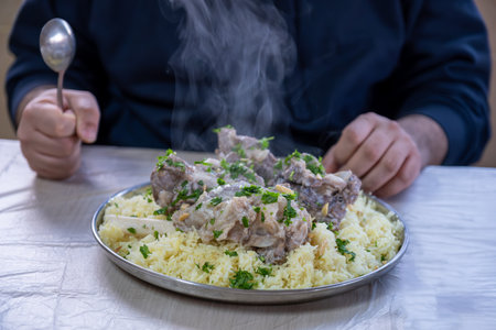hot fresh mansaf steam with hands around it ready to be eaten on family table for iftarの写真素材