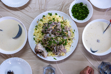Jordanian mansaf on family table for dinner ready to be eaten looks hot and fresh with meat and almonds toppingの写真素材