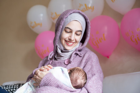 mother holding her newborn in her hand and feeling love for her 1st month of life passed with safe...
