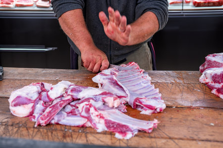 Man butchers trimming a Sheep to be distributed during Eid Al-Adha Al Mubarakの写真素材