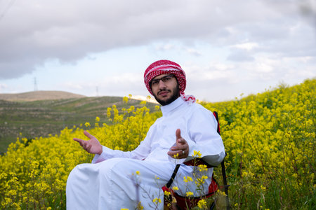 An individual sits in a golden field of flowers at sunrise, arms raised in positivity. The fresh spring air and vibrant sky symbolize health and freedom capturing a moment of harmony and adventureの写真素材