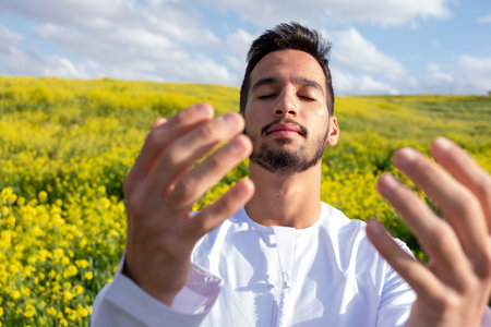 An Arab people enjoys a spring picnic in a meadow near Abu Dhabi. Seated on chairs, they savor cups of coffee under a blue sky with scattered cloudsの写真素材