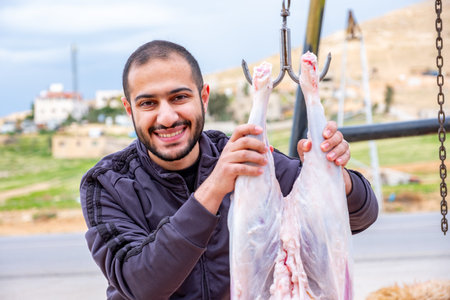 Muslim man trimming a sheep to be distributed to those in need during Eid Al-Adhaの写真素材
