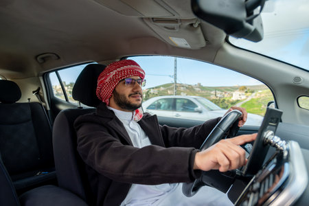young arab male using phone while driving looking maps or callingの写真素材