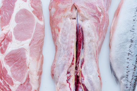 Bearded man cutting meat in butcheryの写真素材
